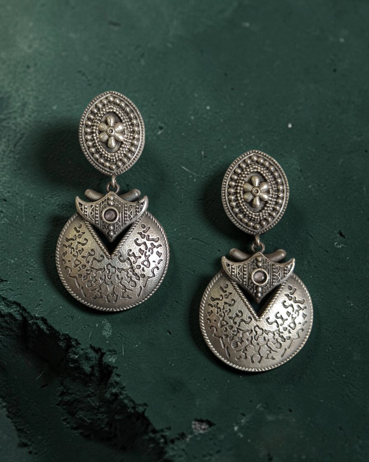 Brass construction supports the darkened patina of this earring.