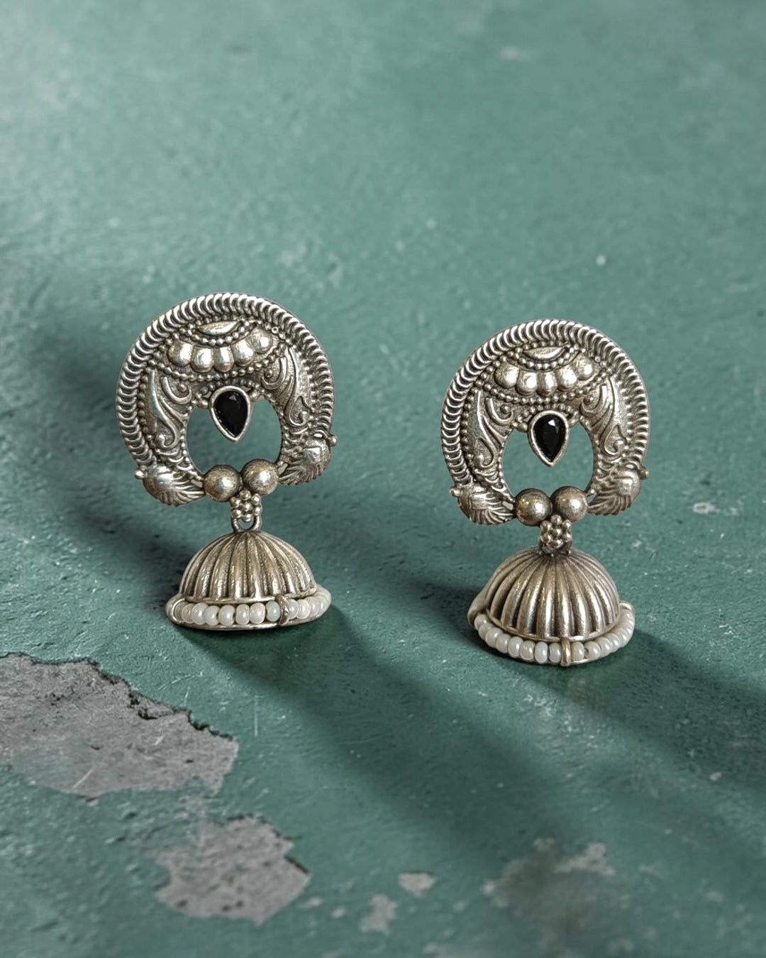Brass construction supports the lightweight bell-shaped jhumka design.