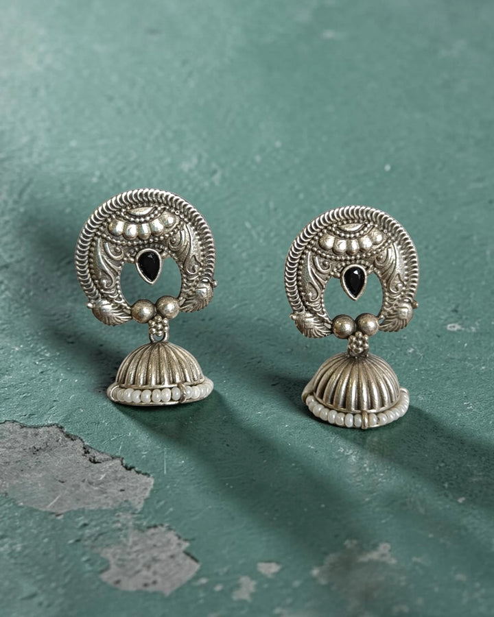 Brass construction supports the lightweight bell-shaped jhumka design.