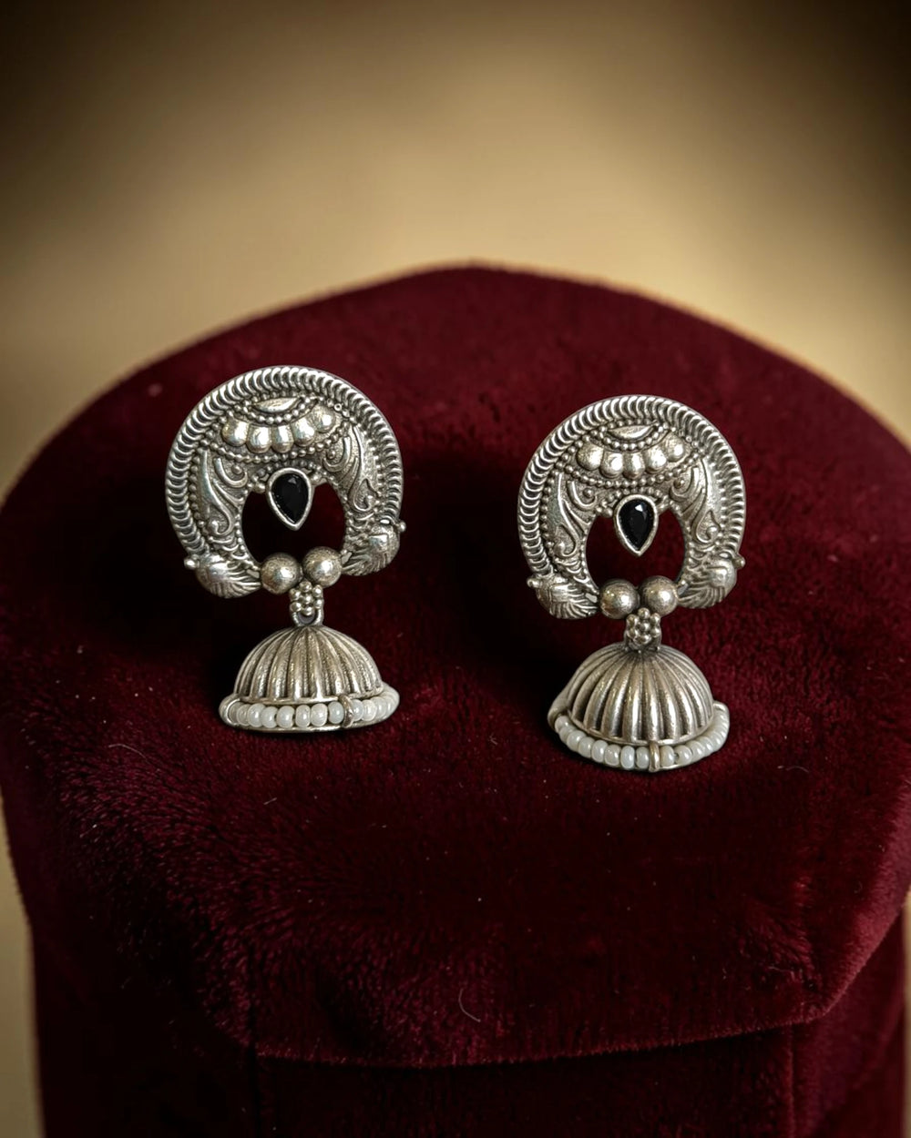 Silver oxidised finish covers the textured surface of this earring.