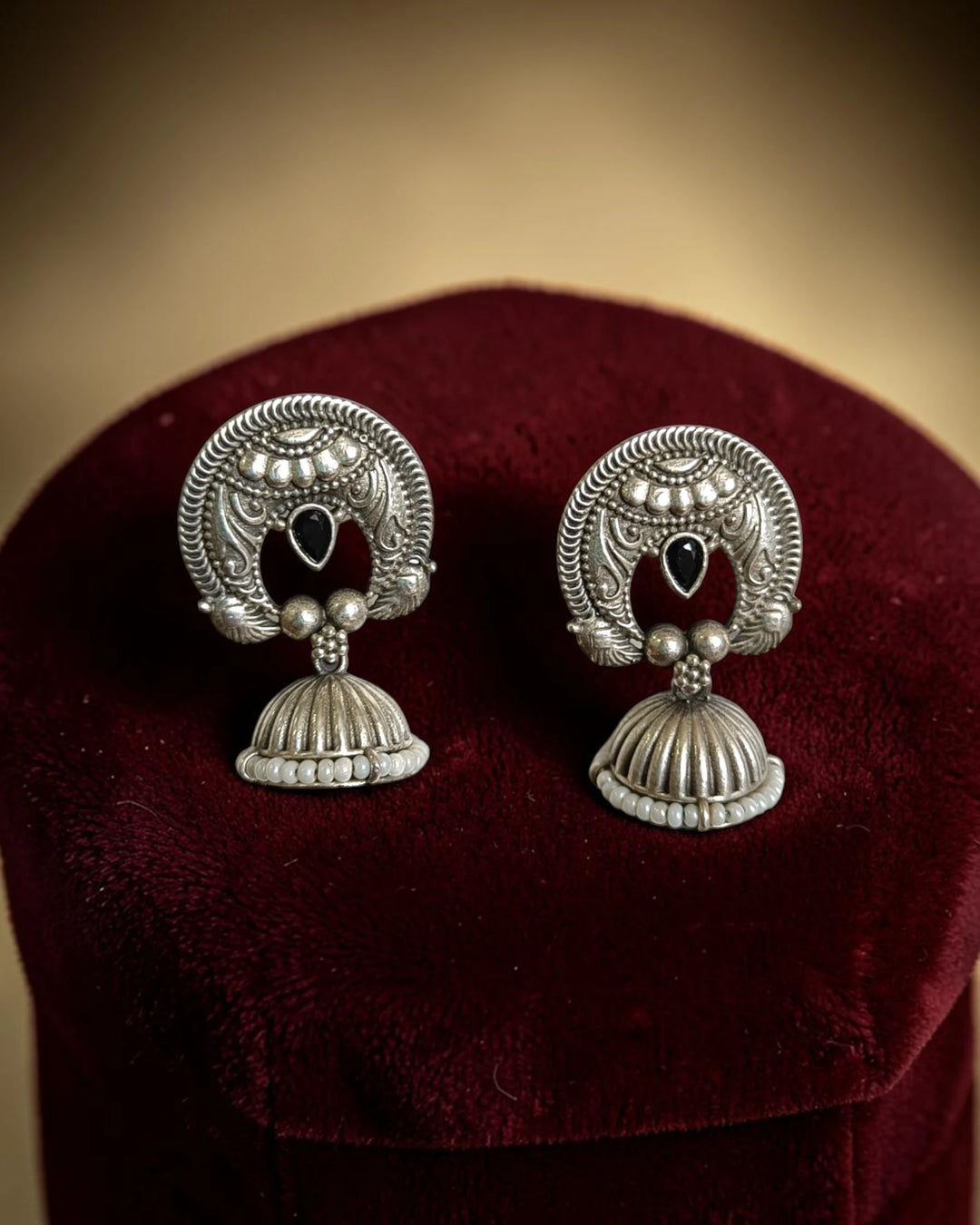 Silver oxidised finish covers the textured surface of this earring.
