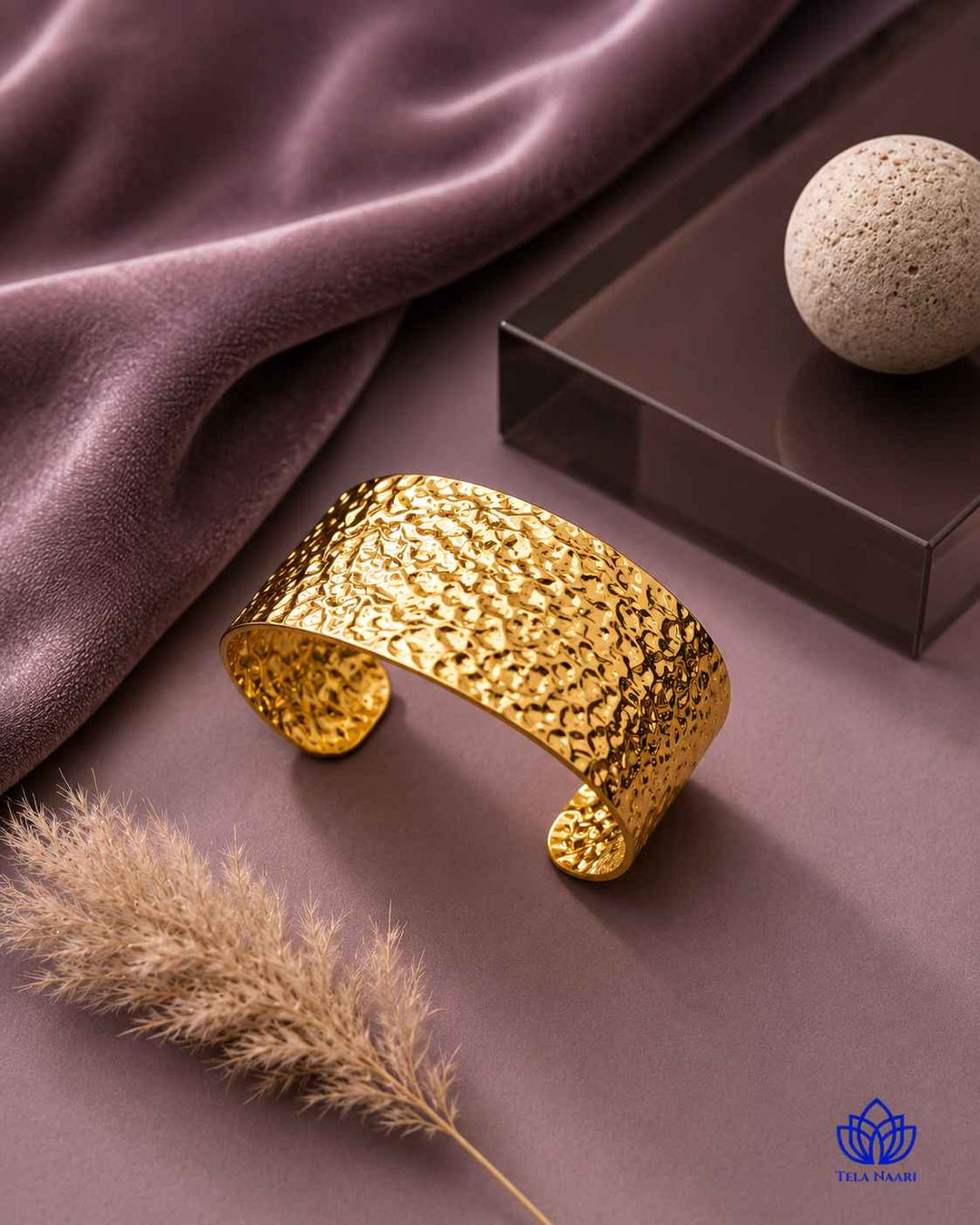 Polished gold surface reflects the striking hammered detail throughout.
