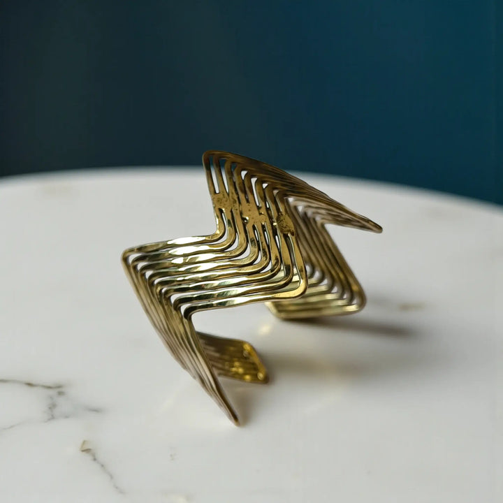 hand bracelet for women with modern sculptural detailing and polished brass texture
