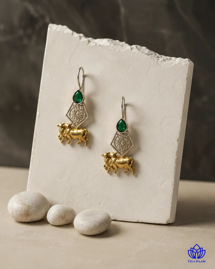 Brass construction supports the sacred motif of this earring.