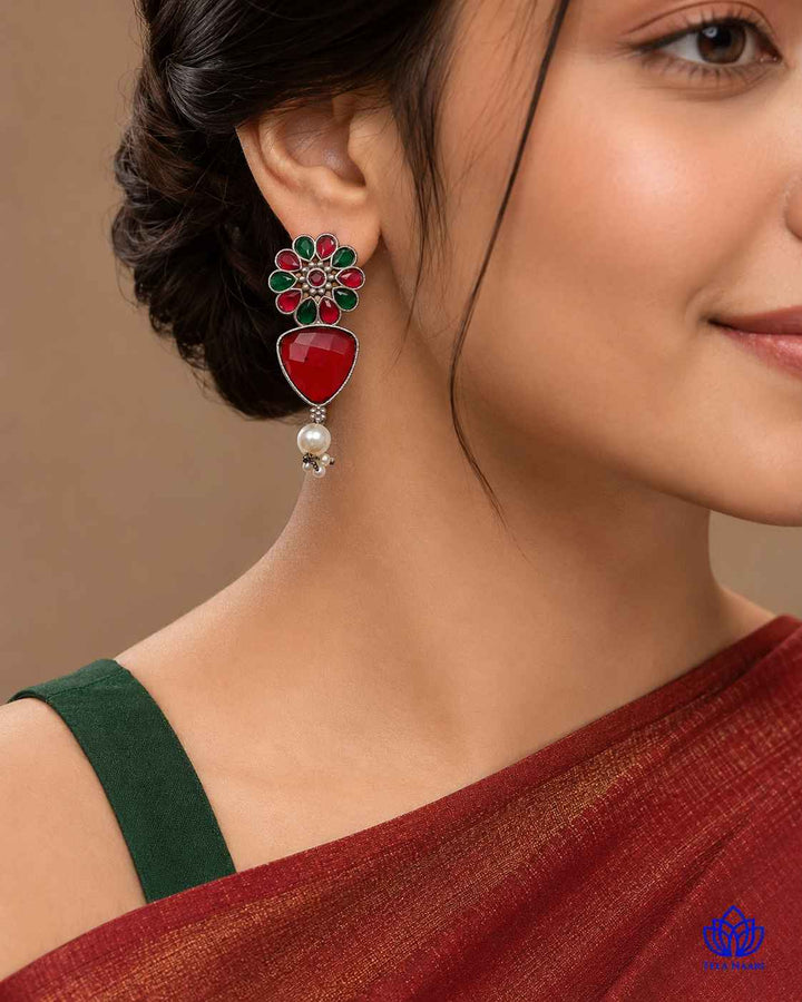 Green accents highlight the red tones of this earring design.