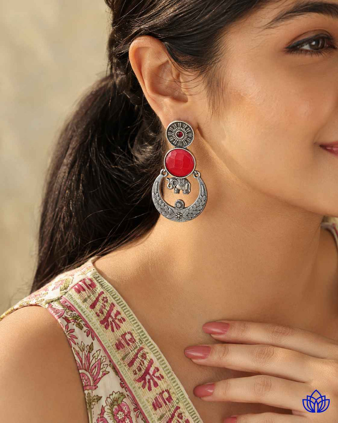 Fiery red stone shapes the silhouette of this earring.