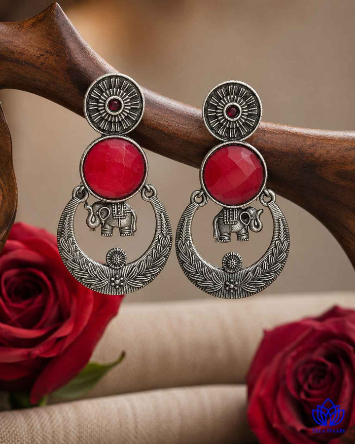 Silver-plated finish covers the surface of this red earring.