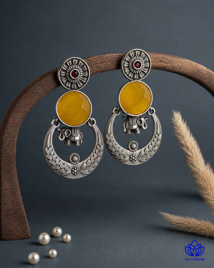 Brass construction supports the stone detailing of this earring.