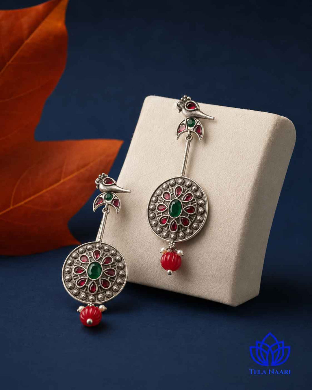 Stone and glass bead detailing decorate this bird-motif earring.