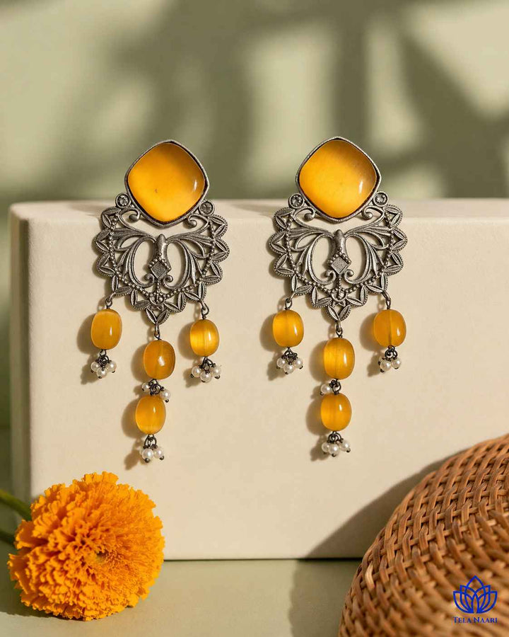 Elegant silhouette pairs yellow detailing with a dangler shape.