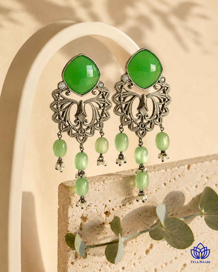 Glass bead accents add texture to this green dangler earring.