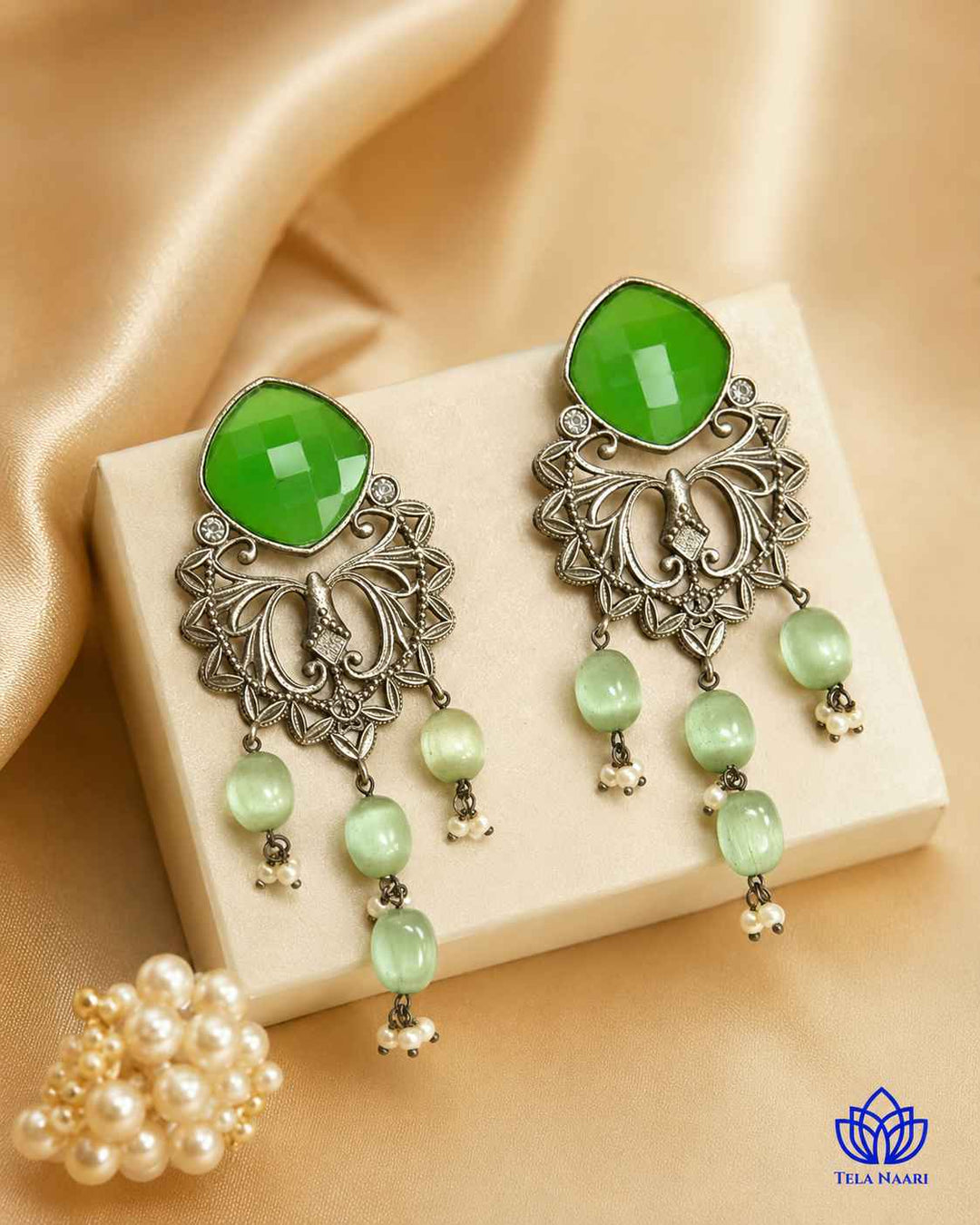 Verdant green stone shapes the silhouette of this dangler earring.