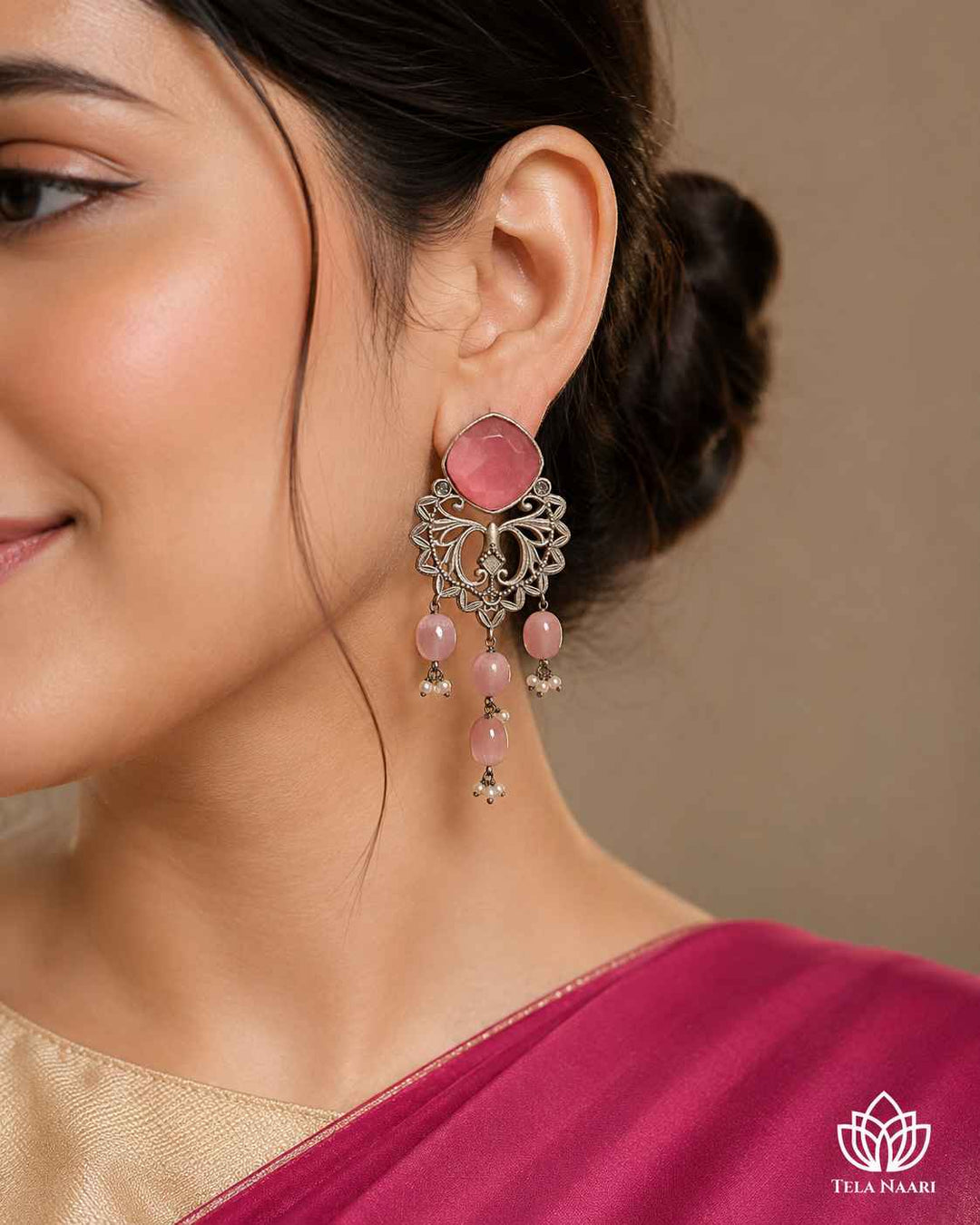 Blossoming pink stone shapes the silhouette of this dangler earring.