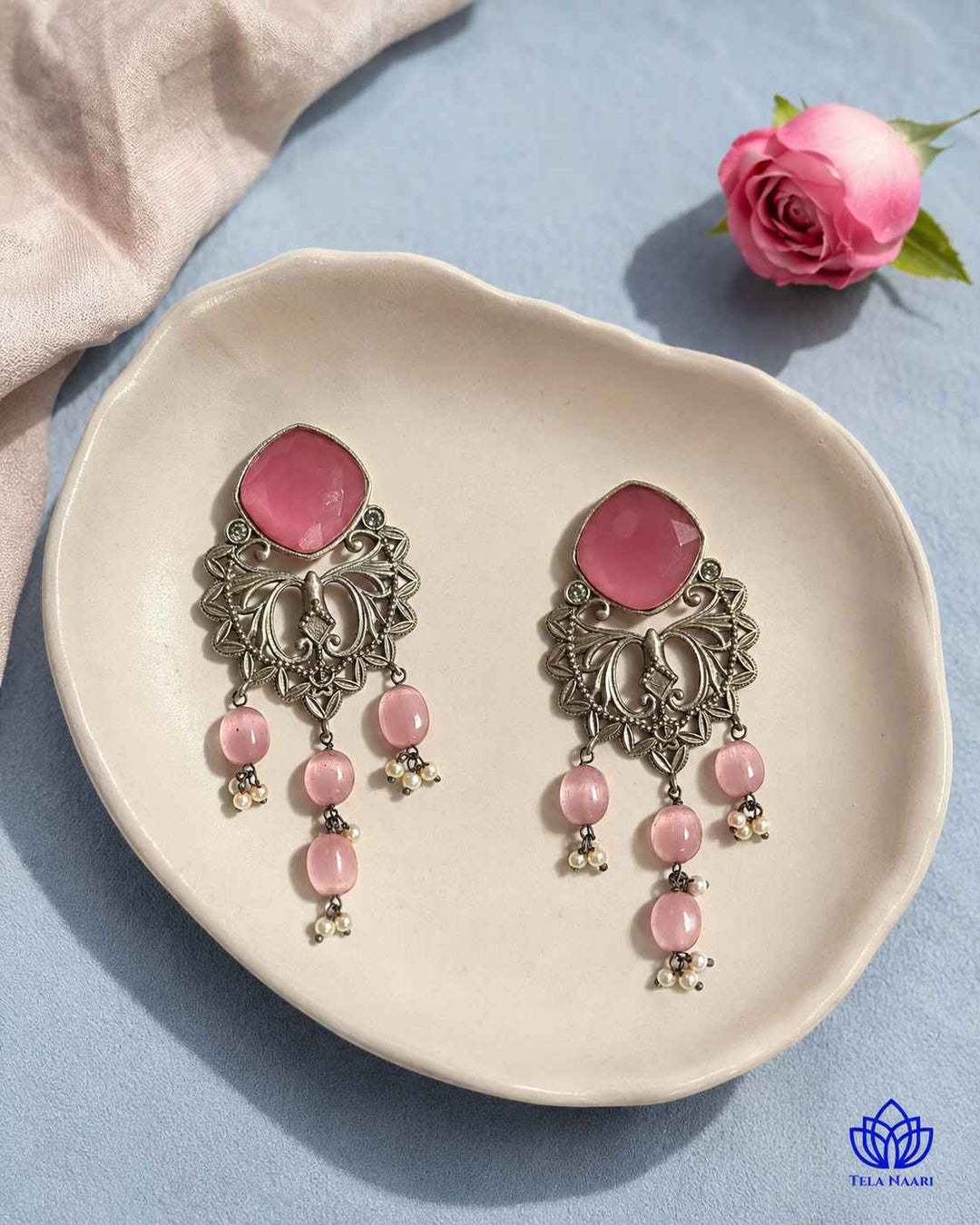 Glass bead accents add texture to this pink dangler earring.