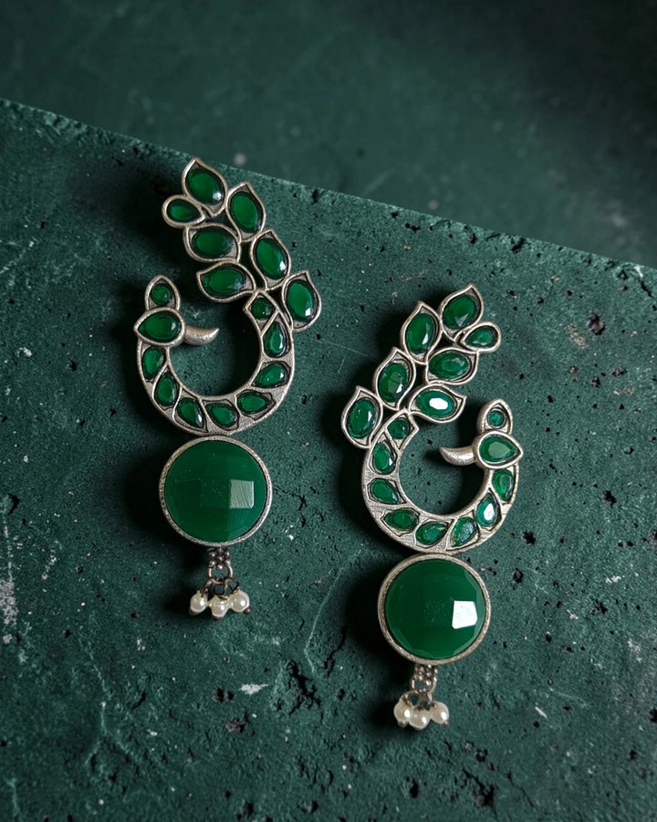 Silver-plated finish covers the surface of this peacock motif earring.