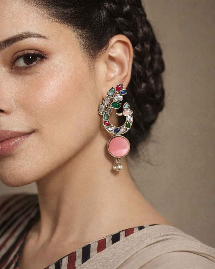 Graceful peacock detailing shapes the silhouette of this earring.