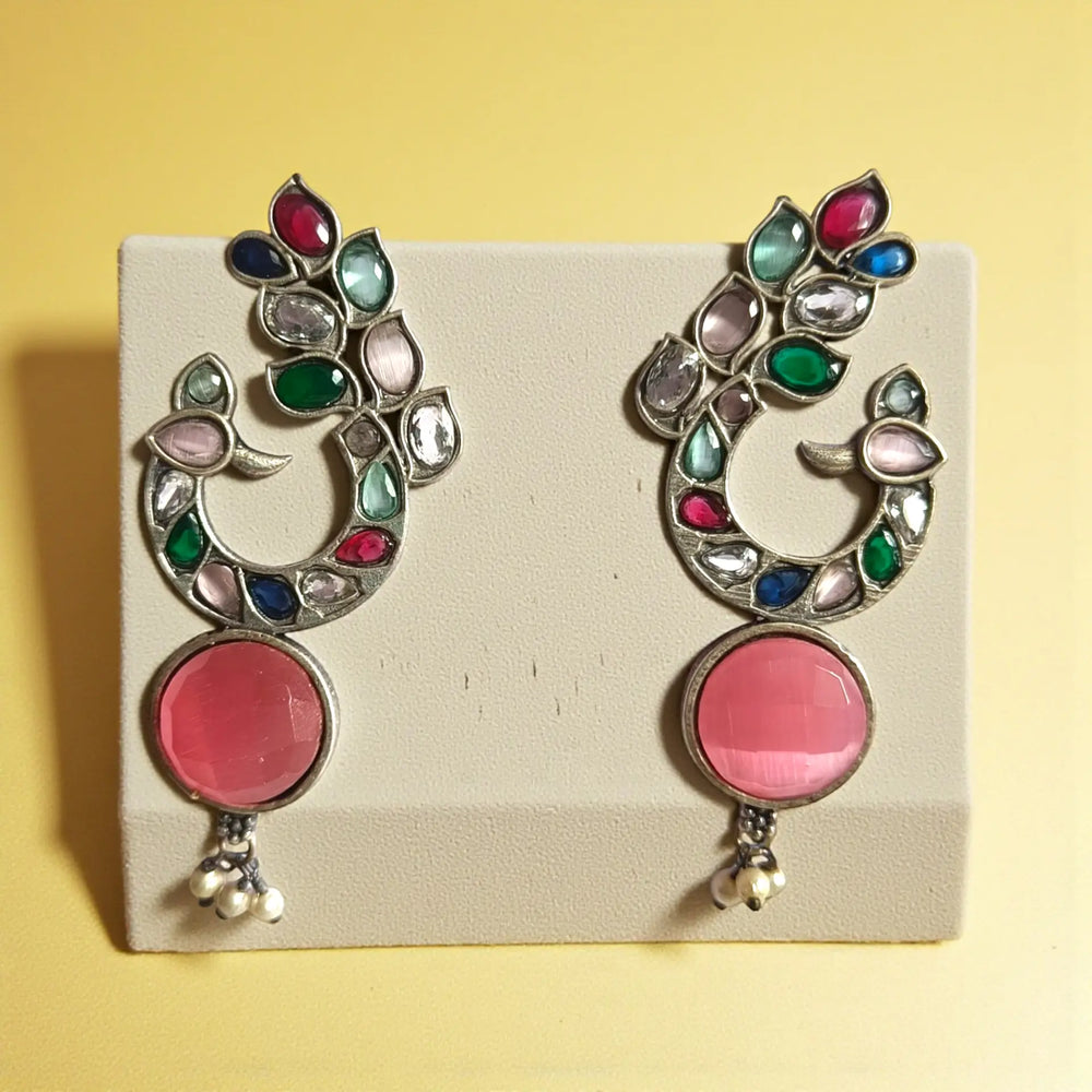 Pink tones brighten the surface of this peacock motif earring.