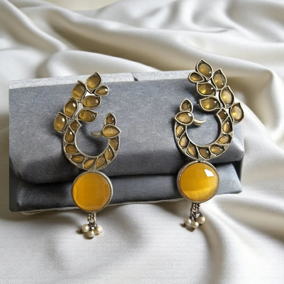 Ornamental peacock detailing shapes the silhouette of this earring.