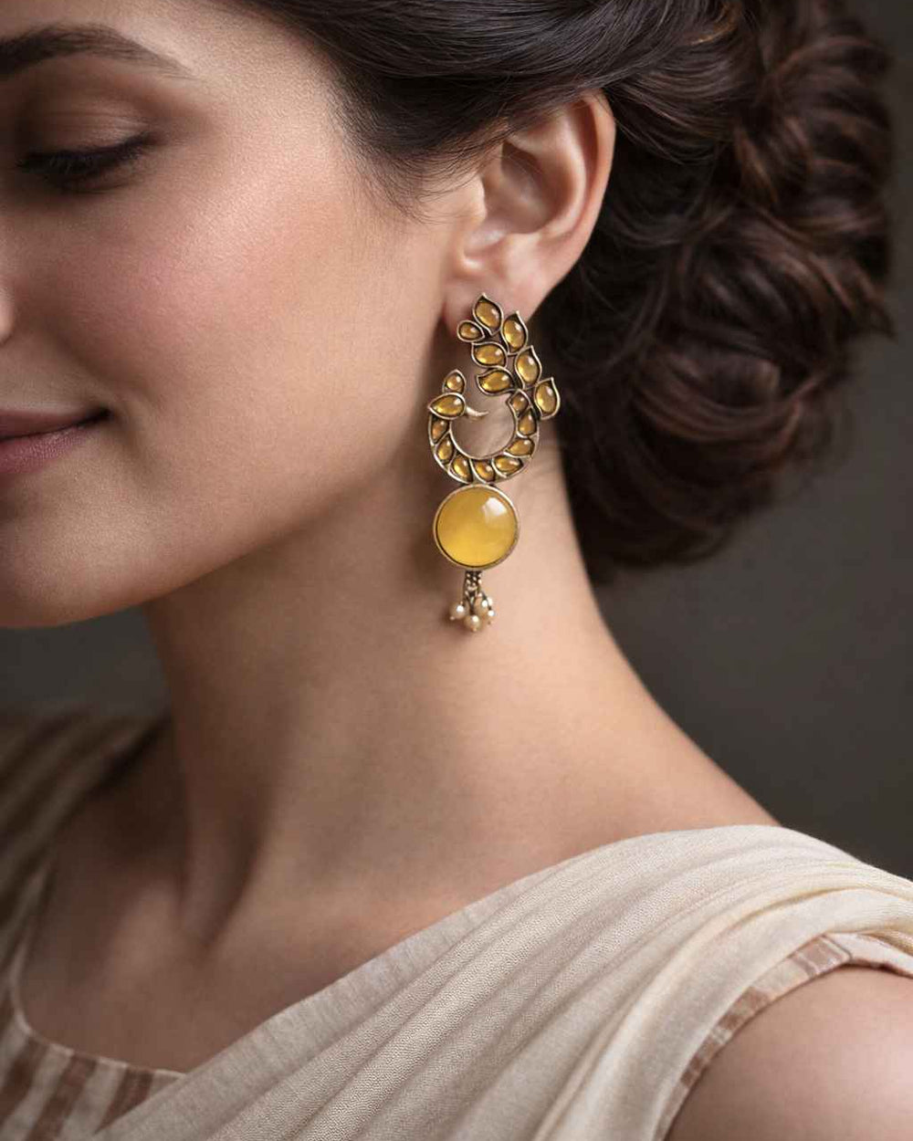 Stone and glass bead detailing decorate this yellow peacock earring.