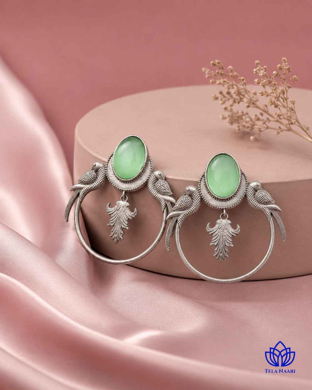 Brass construction forms the base of this parrot-motif earring.