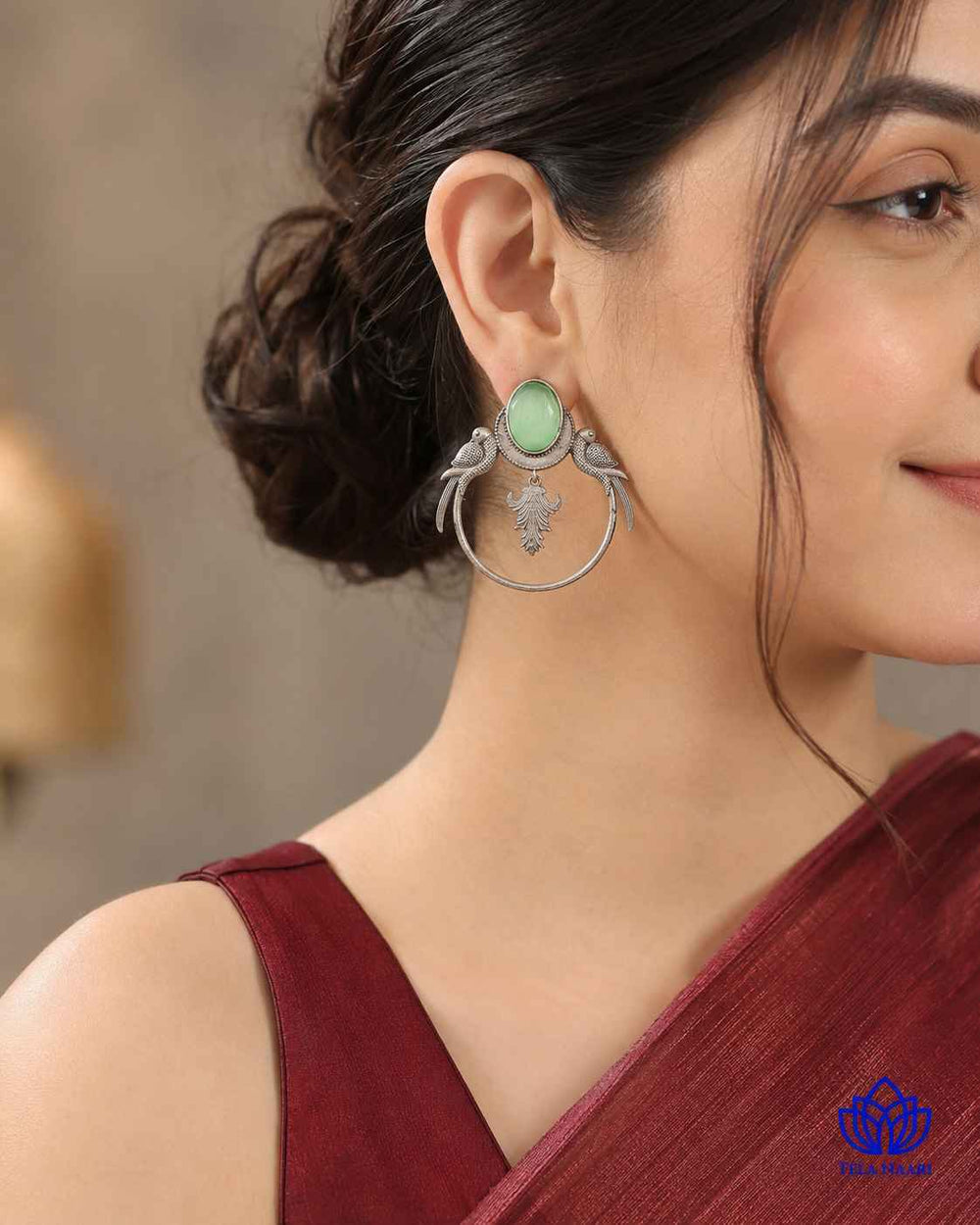 Light green tones highlight the parrot silhouette of this earring.
