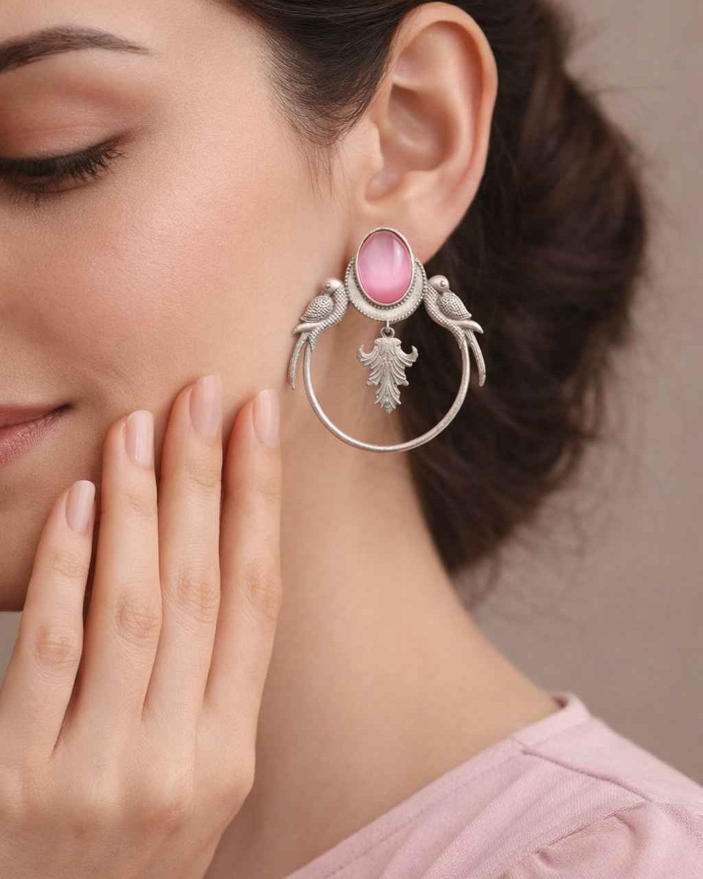 Whimsical parrot motif shapes the silhouette of this pink earring.