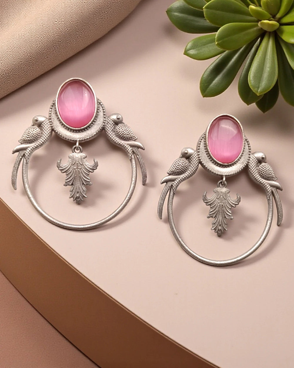 Silver-plated finish covers the surface of this pink parrot earring.