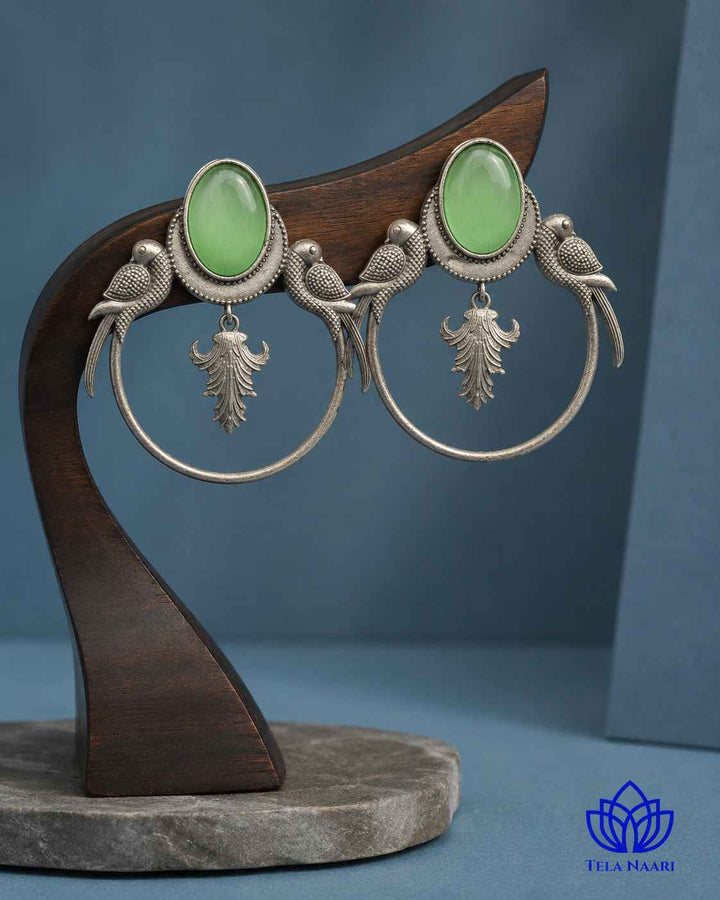 Quirky parrot design sits within a smooth silver-plated frame.