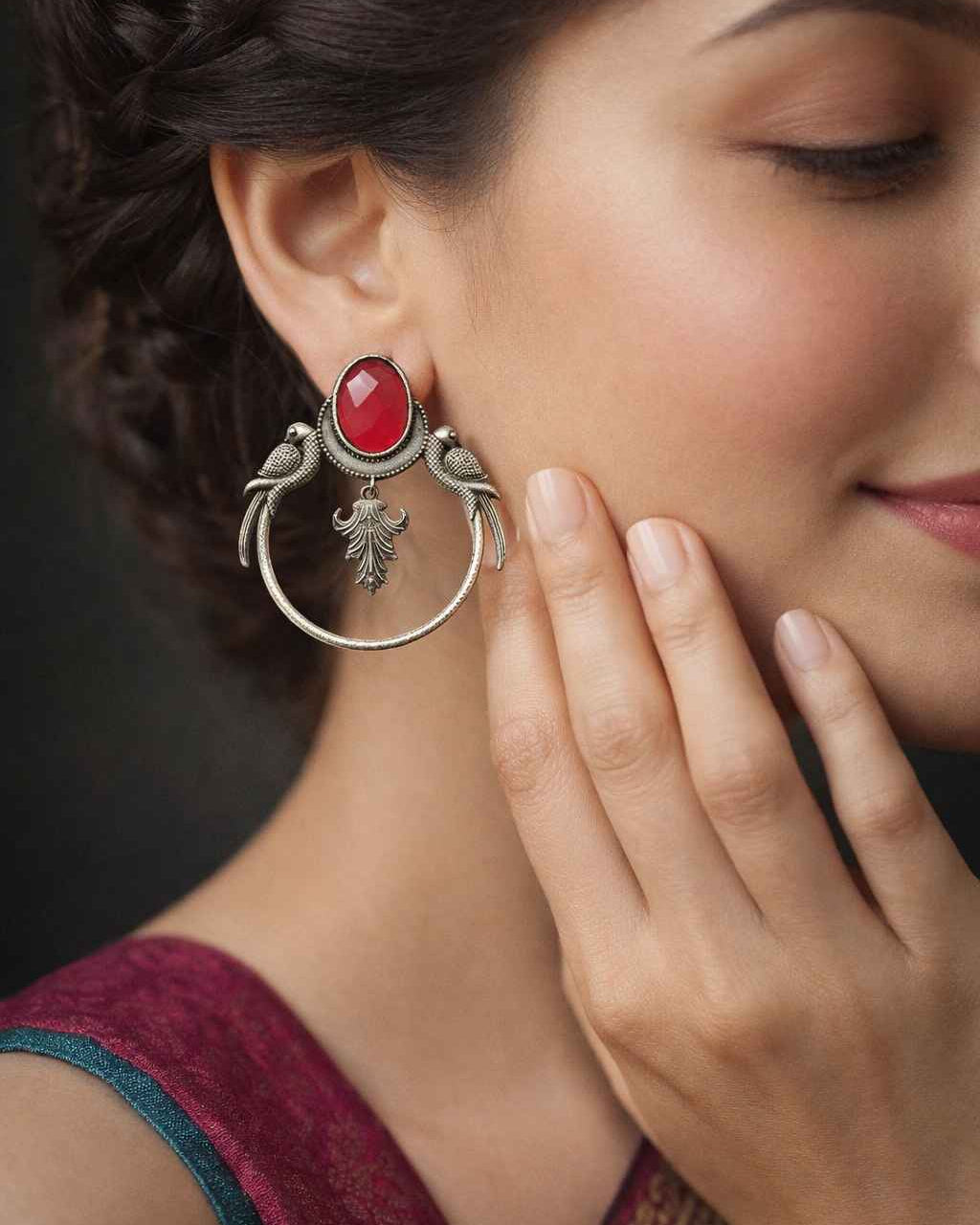 Quirky parrot motif shapes the silhouette of this red earring.