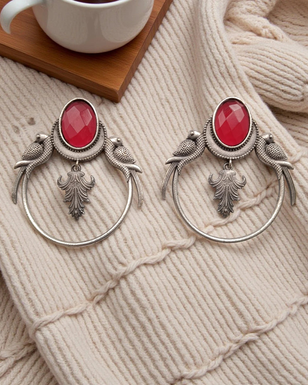 Silver-plated finish covers the surface of this red parrot earring.