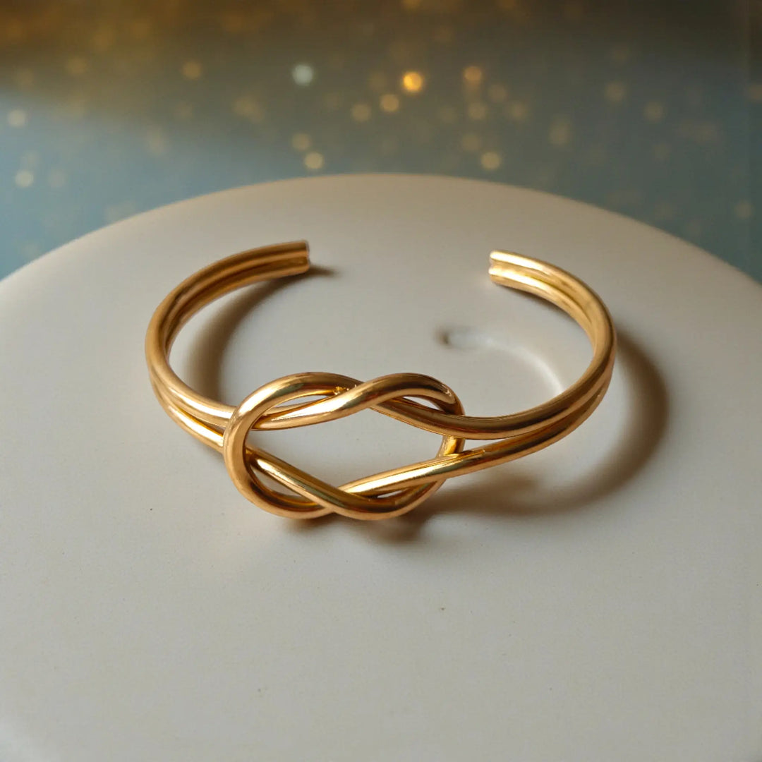 Symbolic infinity knot detailing shapes the silhouette of this cuff.