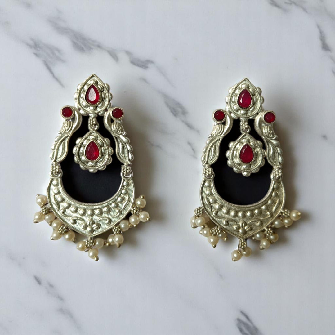 Silver oxidised craftsmanship covers the surface of this earring.