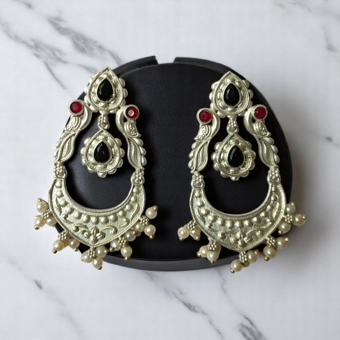 Sky blue tones brighten the oxidised surface of this earring.