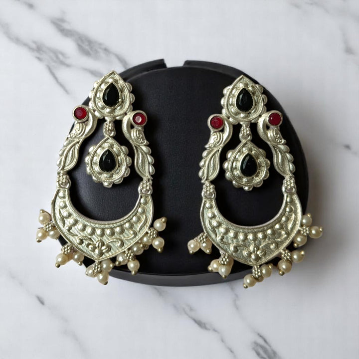Sky blue tones brighten the oxidised surface of this earring.