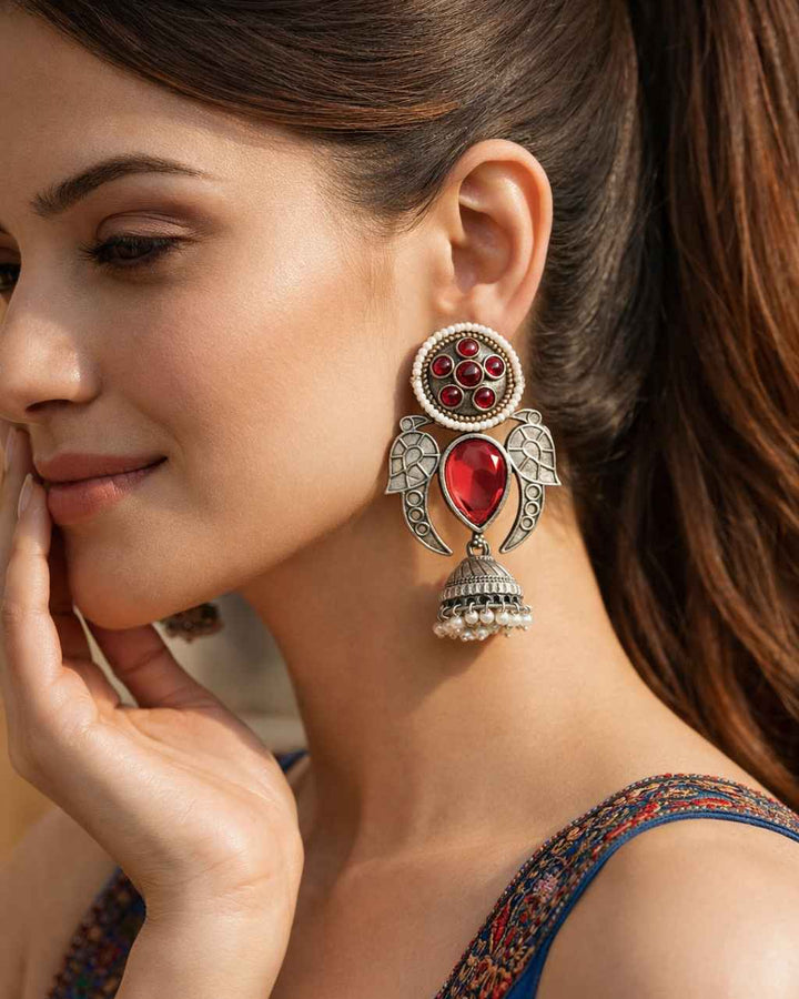 Brass construction supports the stone and glass bead detailing of this earring.
