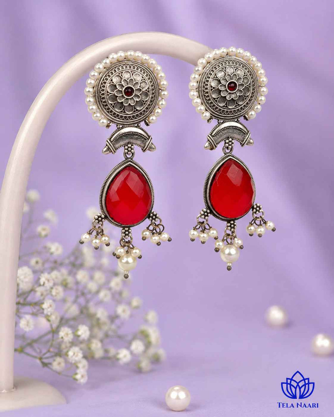 Delicate beadwork adds texture to this red teardrop earring.