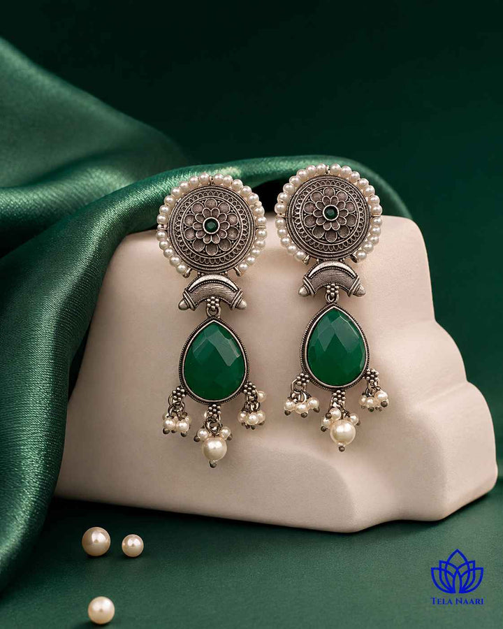 Glass bead accents add texture to this red and green earring.