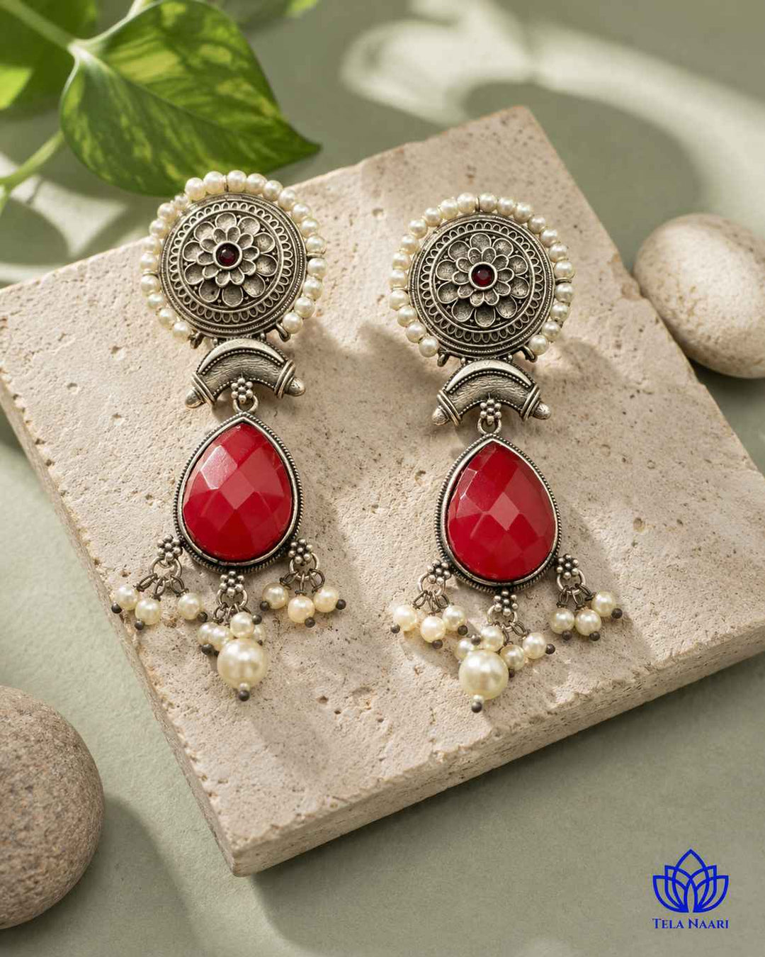 Graceful teardrop silhouette defines this red silver oxidised earring.