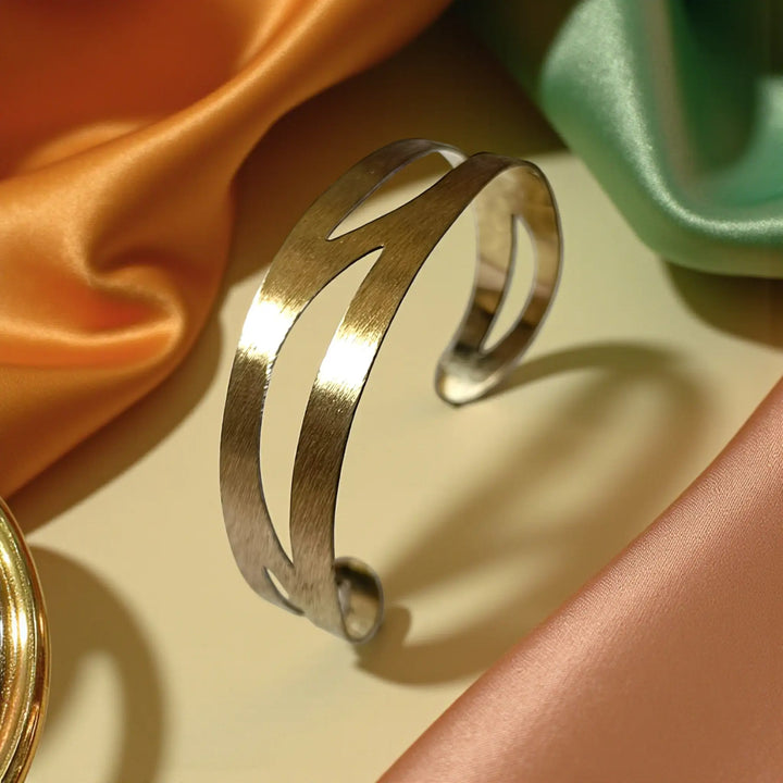 Precision-cut apertures shape the geometric pattern of this brass cuff.