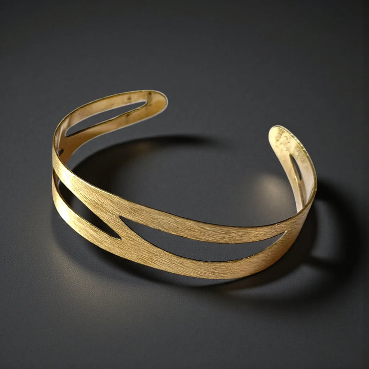 Geometric apertures define the modern silhouette of this cuff bracelet.