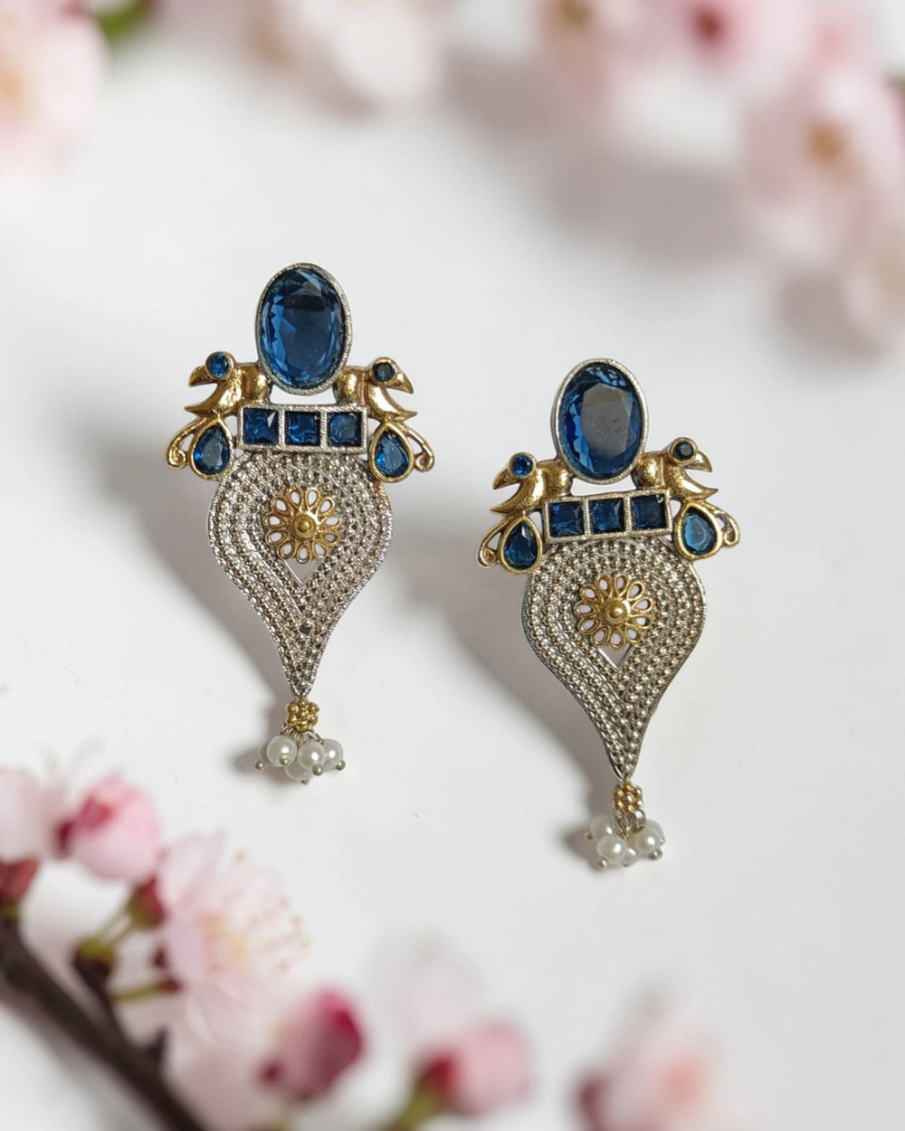 Brass construction supports the lightweight peacock design of this earring.