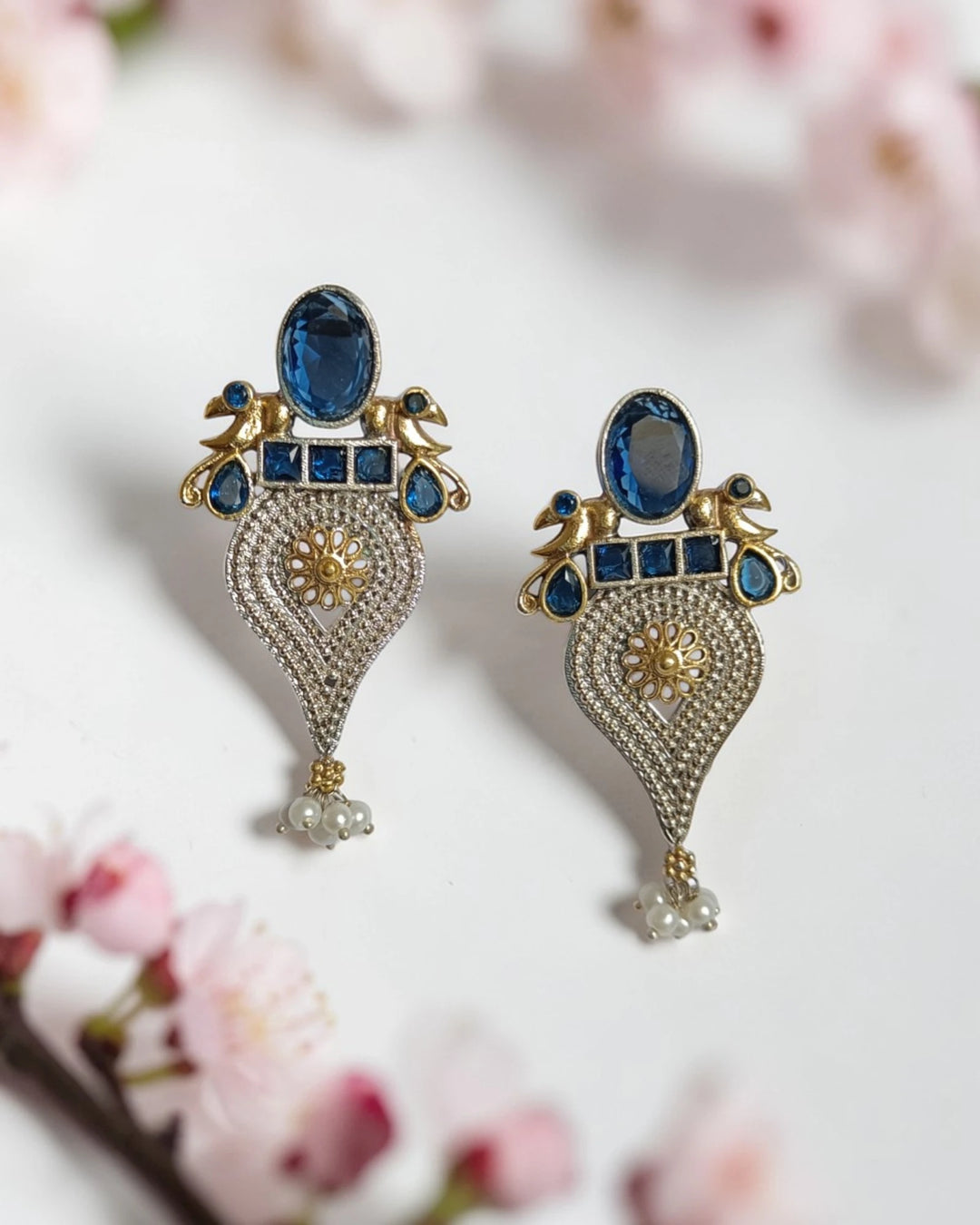 Brass construction supports the lightweight peacock design of this earring.
