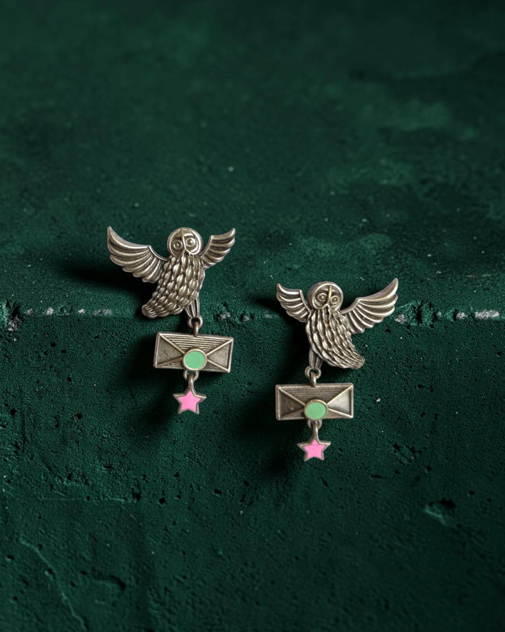 Sea green accents highlight the surface of this owl-motif earring.