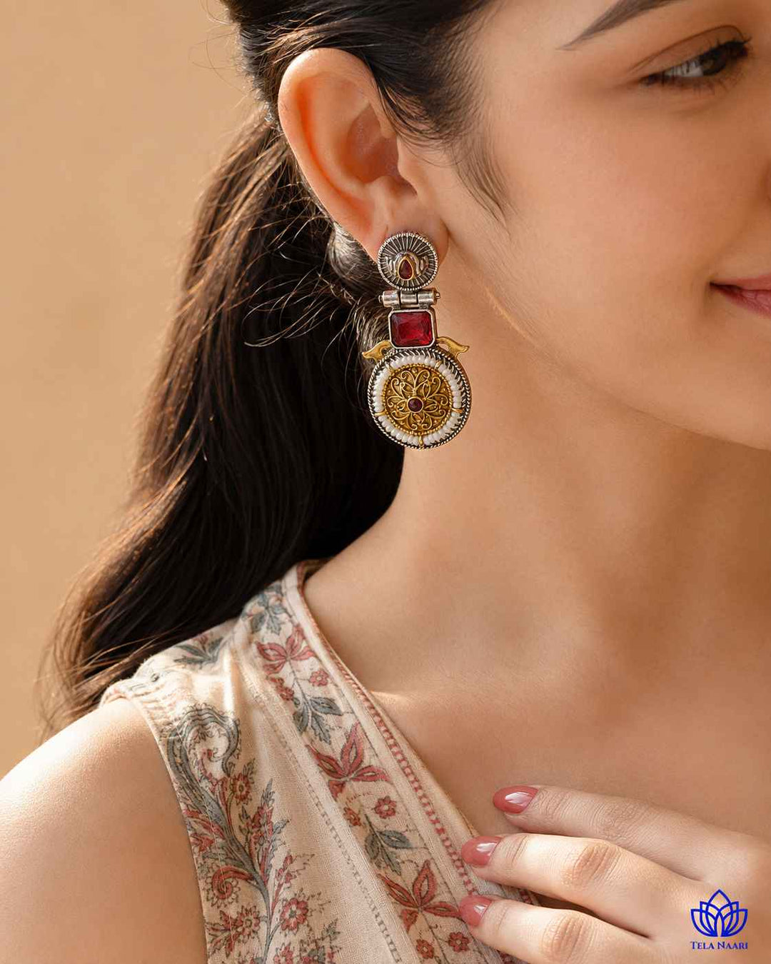 Metallic contrast defines the two-tone finish of this red earring.