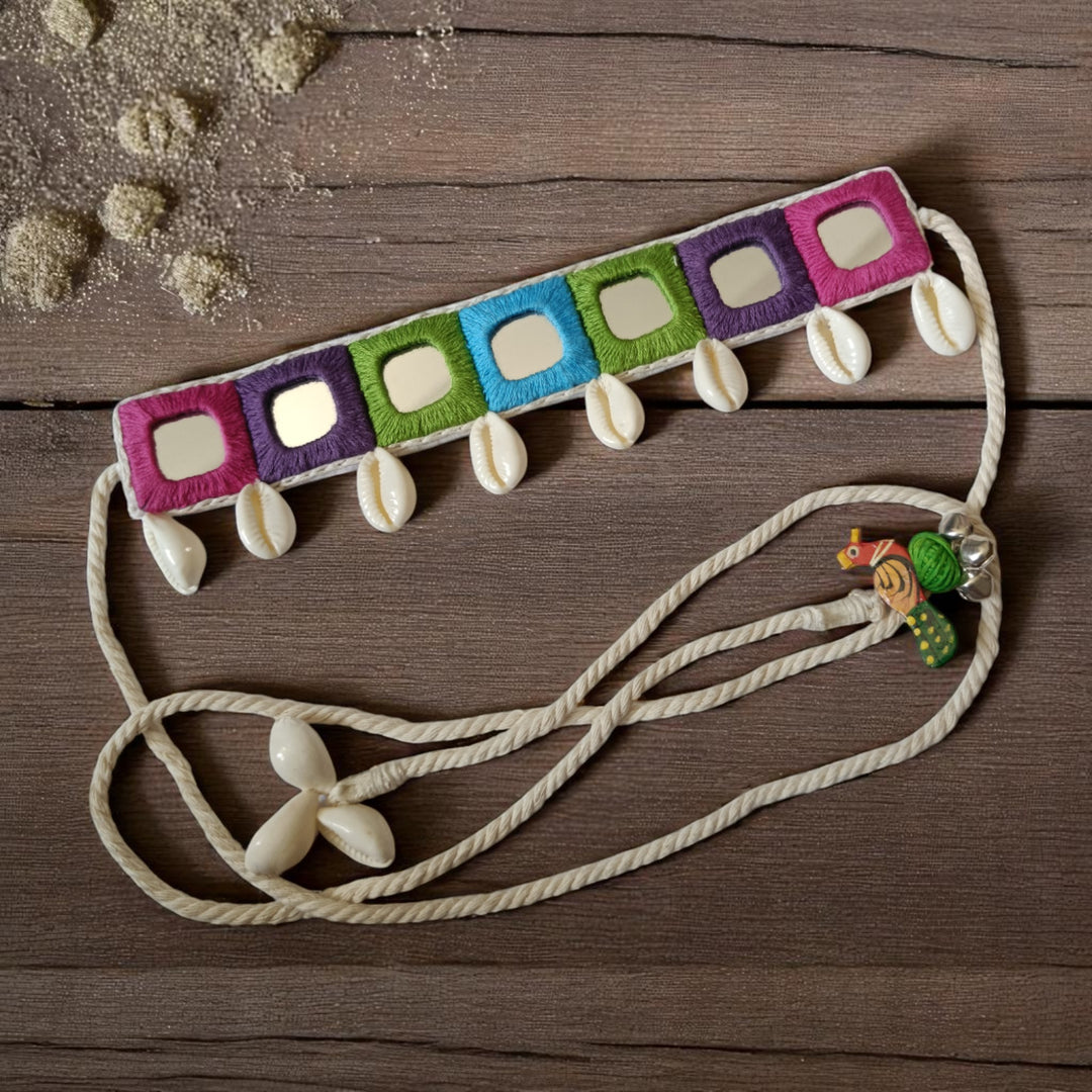 Authentic cowrie shells decorate the surface of this fabric choker.