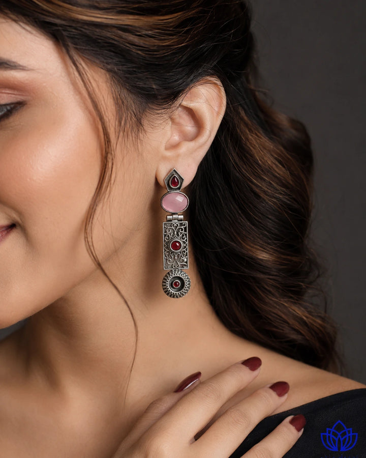 Bold statement silhouette pairs oxidised alloy with pink stones.