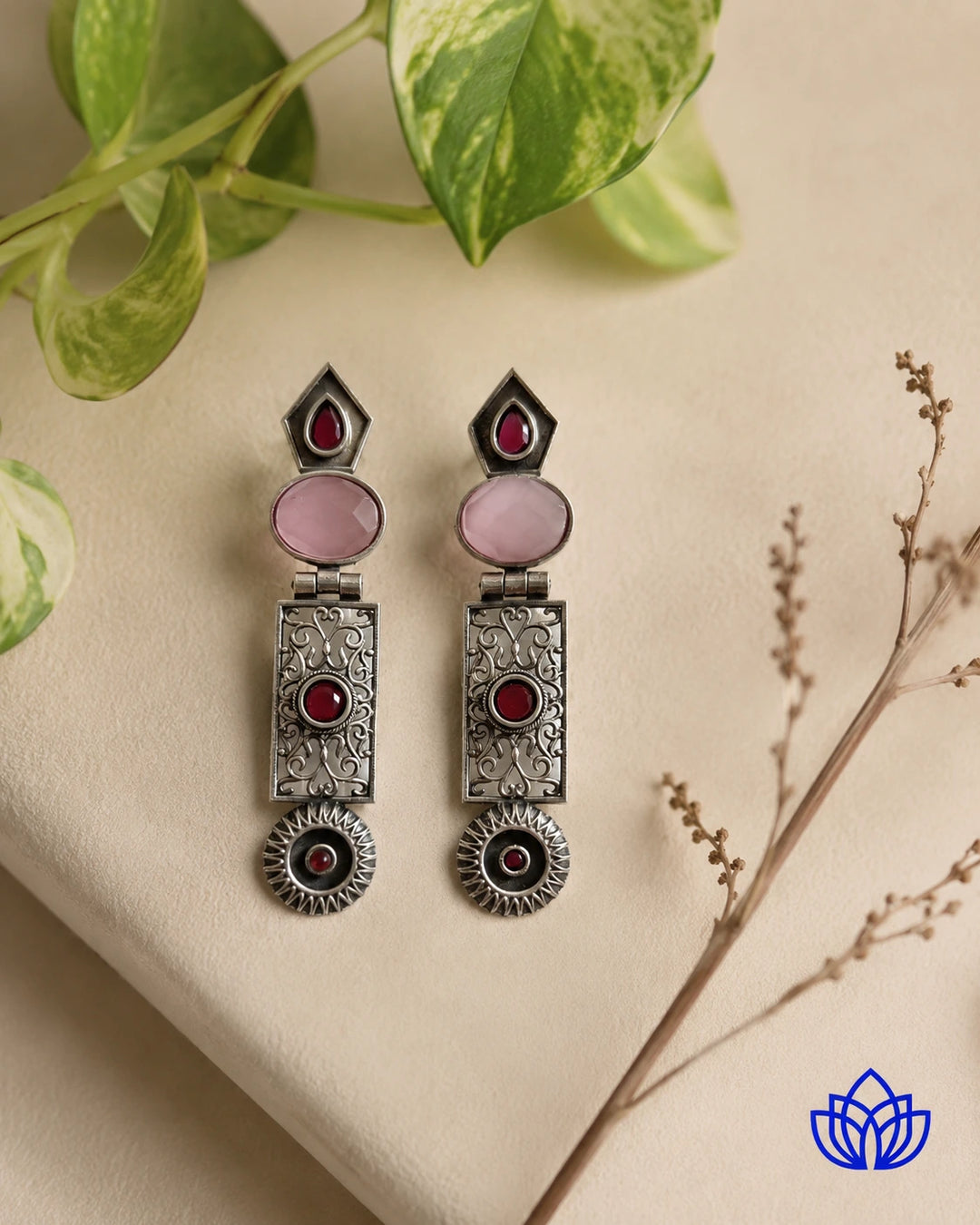 Artisanal antique-finish metalwork shapes this pink statement earring.