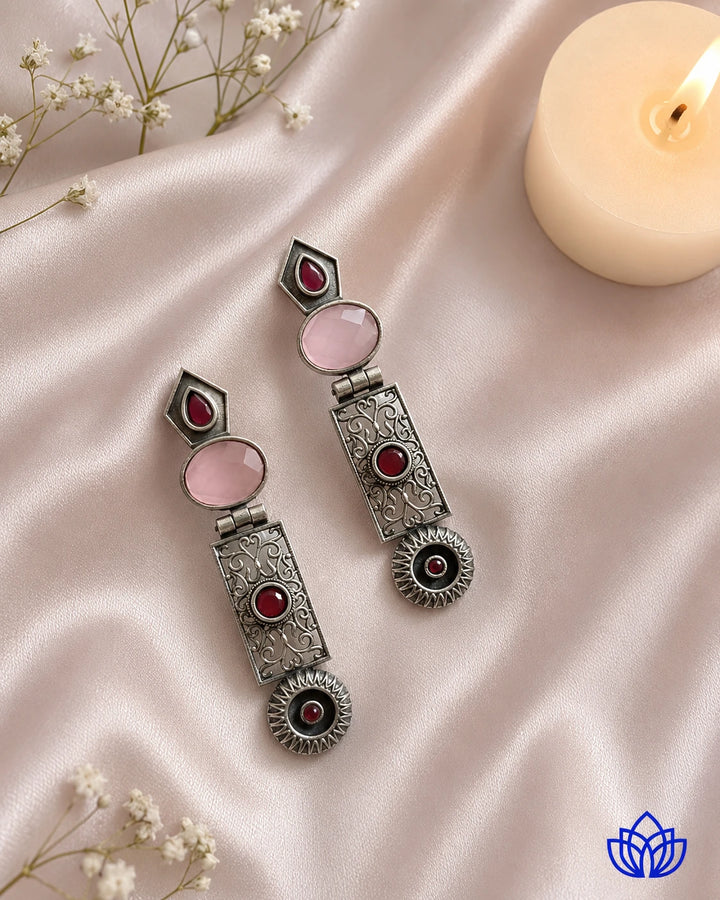 Pink stone detailing sits at the centre of this statement earring.