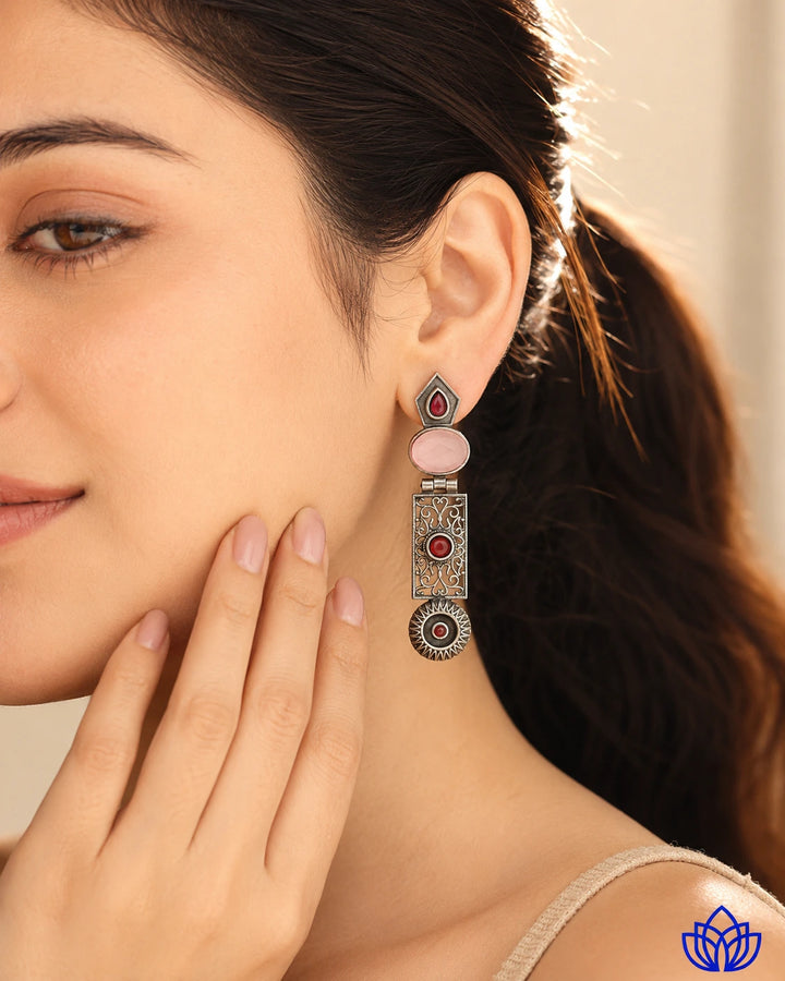 Textured alloy surface supports the pink stone detailing of this earring.