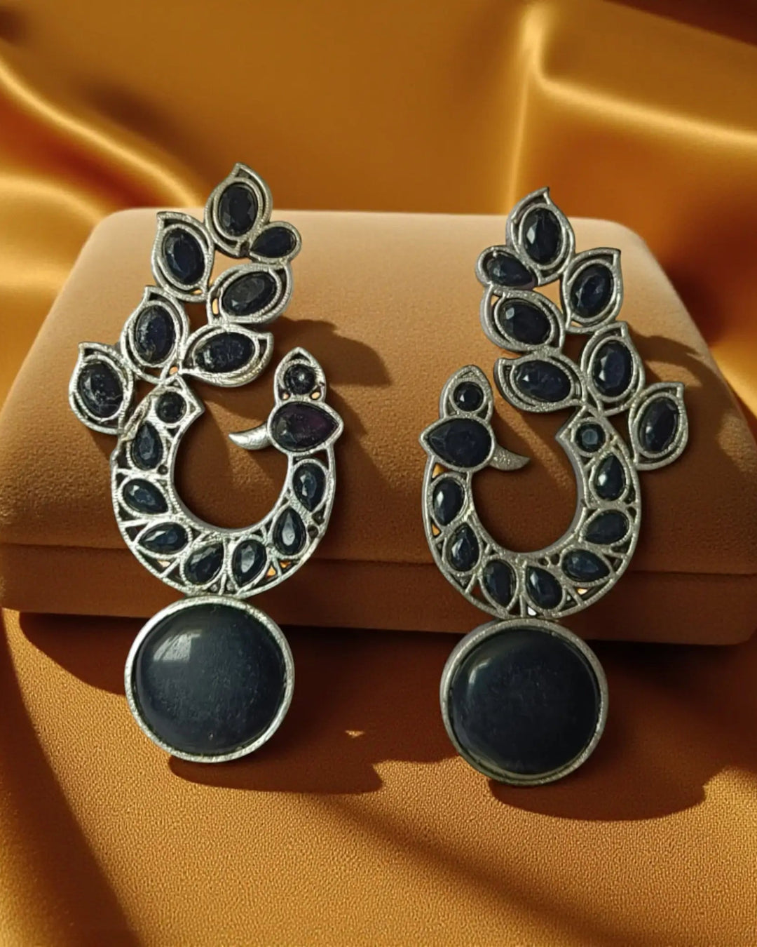 Brass construction supports the intricate pattern of this earring.